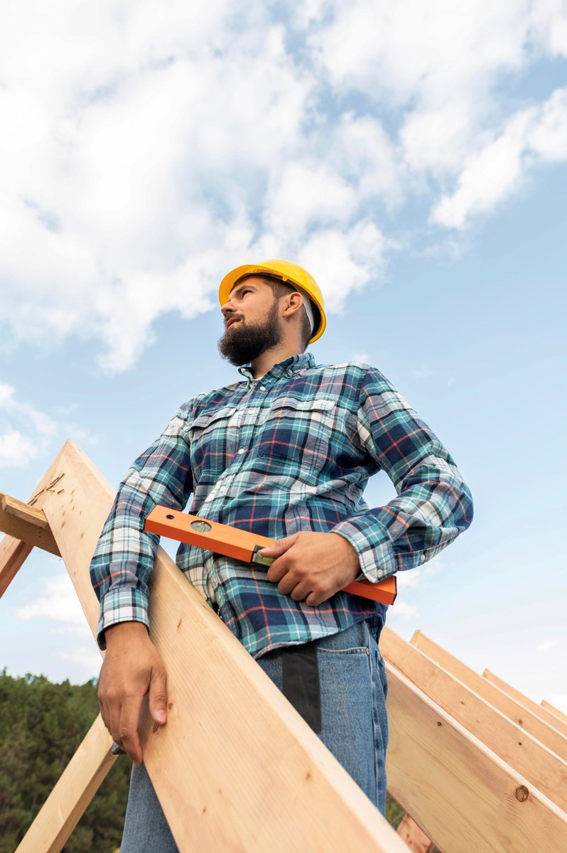 Heritage Roofing crew member carrying a rafter